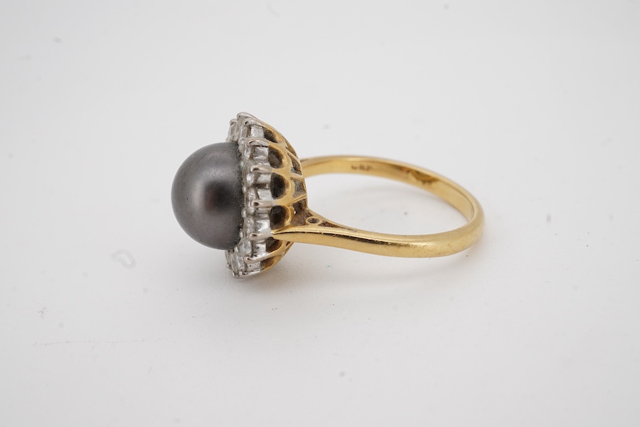 A modern 18ct gold and single stone Tahitian cultured pearl and diamond set circular cluster ring, size O, gross weight 7 grams.